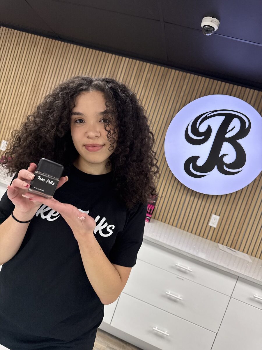 A Toke Folks fan in a Toke Folks tee holding a jar inside BeLeaf