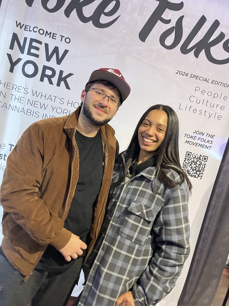 A couple on the Toke Folks magazine cover backdrop
