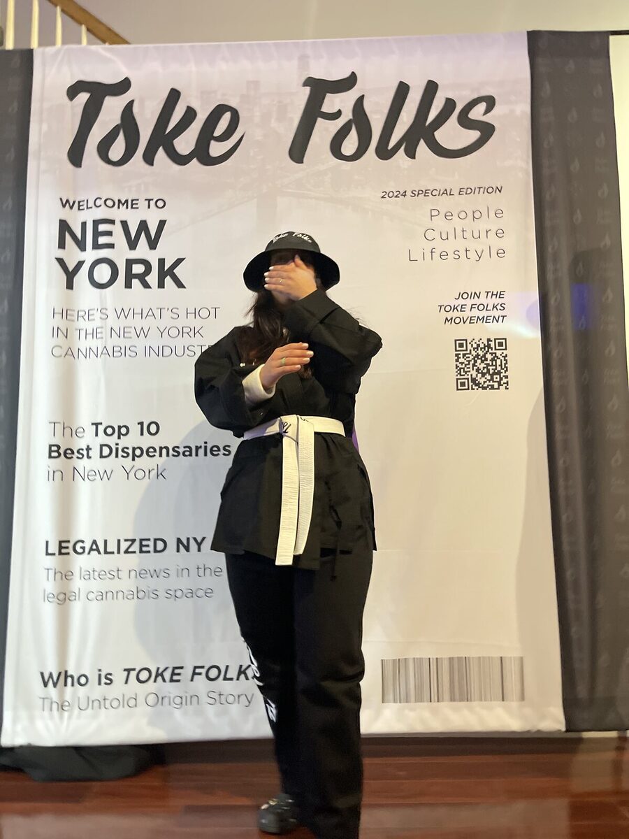 A guest striking a pose on the Toke Folks cover backdrop